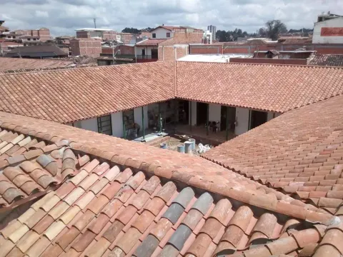 Patio interior rodeado de techos en teja de barro, obra con materiales Madepinos